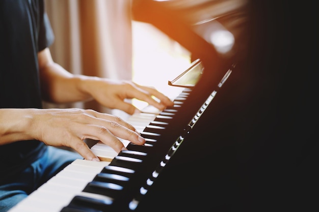 Primo piano di mano persone uomo musicista che suona la tastiera del pianoforte con i tasti di messa a fuoco selettiva può essere utilizzato come sfondo