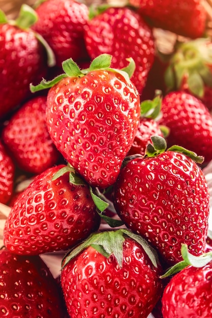 Primo piano di molte fragole appetitose deliziose e succose con foglie pronte da mangiare