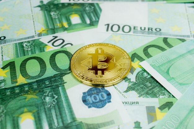 Primo piano di monete bitcoin d'oro su banconote in euro criptovaluta btc