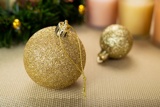 Primo piano di palline di Natale dorate su sfondo giallo metallizzato.