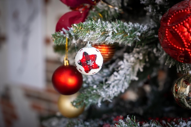 Primo piano di palline dorate e rosse sull'albero di natale. Ghirlande di bokeh in background. Anno nuovo concetto.