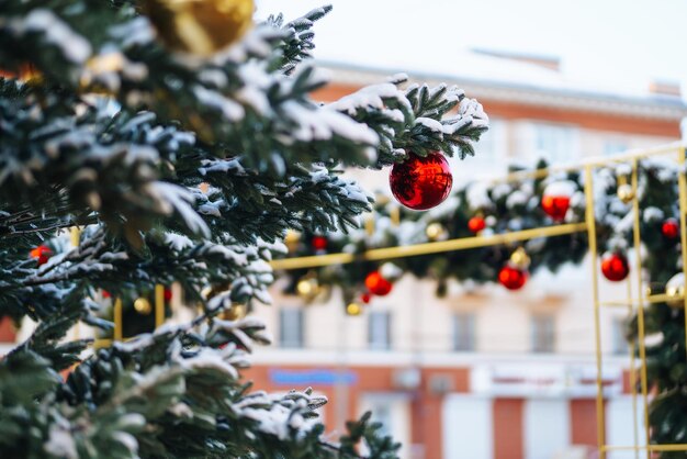 Primo piano di palline su albero di Natale innevato Decorazioni natalizie Concetto di Capodanno Vacanze invernali