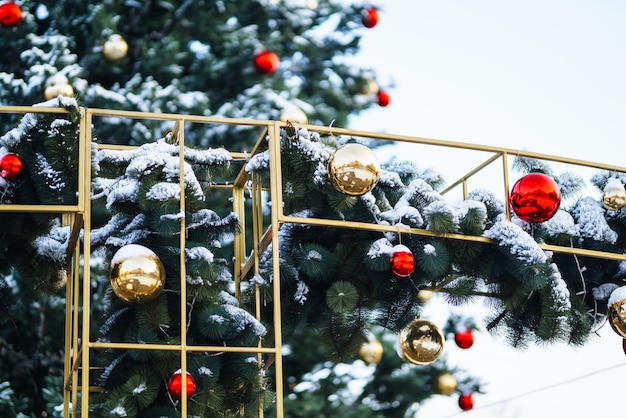 Primo piano di palline su albero di Natale innevato Decorazioni natalizie Concetto di Capodanno Vacanze invernali