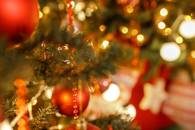 Primo piano di palline su ghirlande di bokeh di albero di natale sullo sfondo del nuovo anno concetto