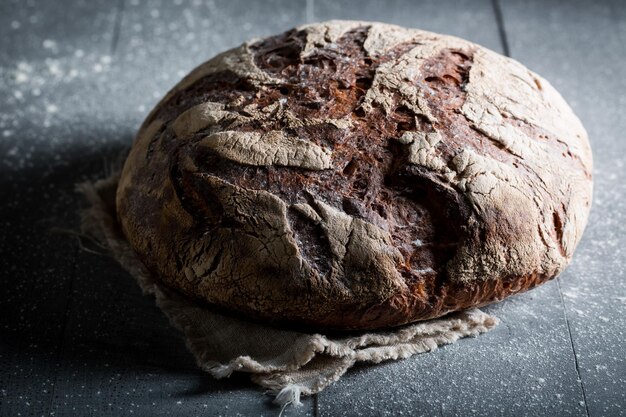 Primo piano di pane con cereali integrali sul tavolo scuro