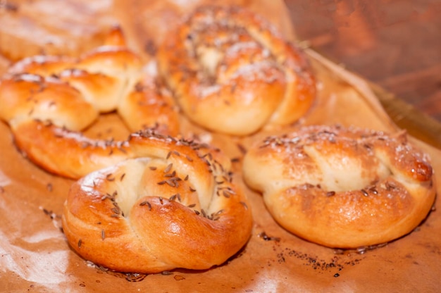 Primo piano di pane su un tavolo appena sfornato, panini dolci al cumino