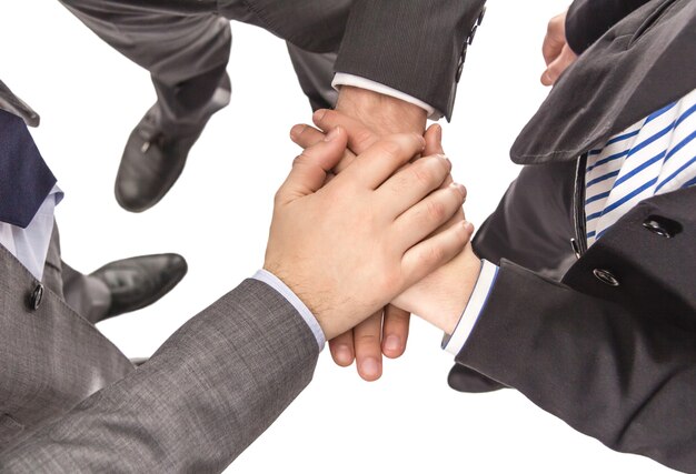 Primo piano di partner commerciali con le mani una sopra l'altra che mostrano potere e unità in un lavoro di squadra