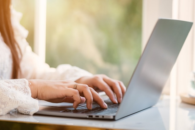 Primo piano di persone freelance businessfemale casual che lavorano con computer portatile e smartphone, tazza di caffè in caffetteria come, concetto di comunicazione