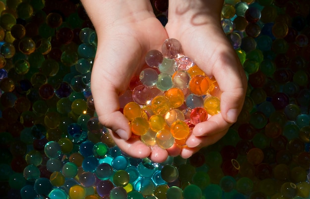 Primo piano di più palline colorate orbis nelle piccole mani di un bambino