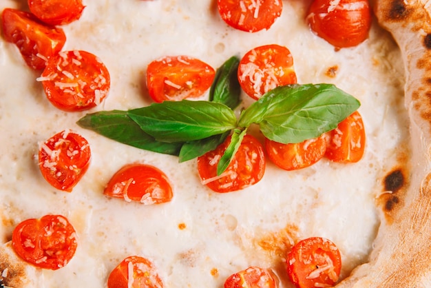 Primo piano di pizza Margherita con formaggio basilico e pomodorini