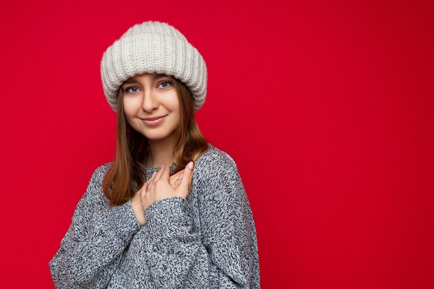 Primo piano di positivo giovane adorabile carino carino biondo scuro donna con emozioni sincere che indossano