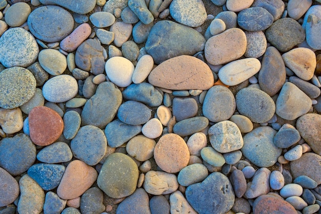 Primo piano di rocce da spiaggia arrotondate e levigate Texture