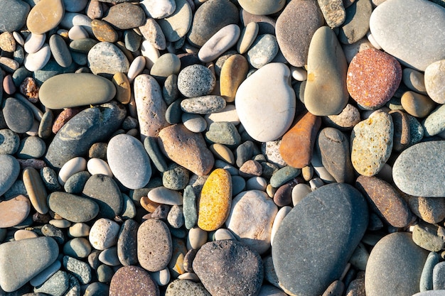 Primo piano di rocce da spiaggia arrotondate e levigate Texture