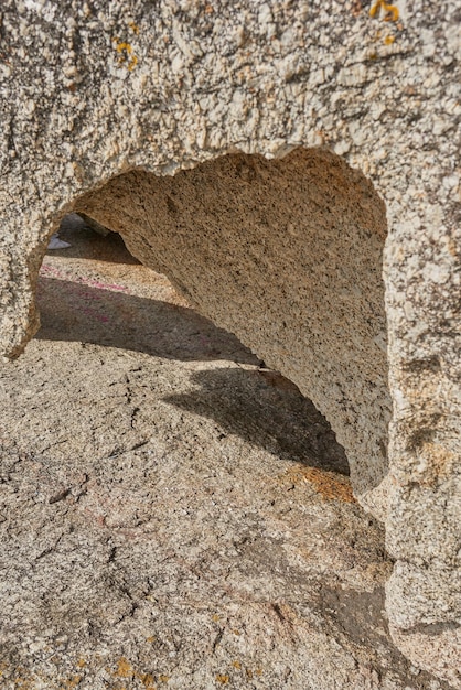 Primo piano di roccia ruvida con crepe profonde, fori e fessure dovute al calore del vento o all'erosione dell'acqua dovuta al riscaldamento globale o al cambiamento climatico Dettaglio della trama e sfondo di roccia sedimentaria o granito all'esterno