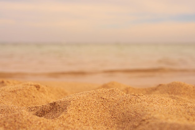 Primo piano di sabbia con mare sfocato sullo sfondo