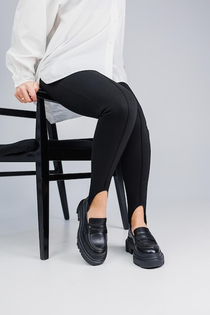 Primo piano di sottili gambe femminili in leggings neri e mocassini in pelle nera Nuova collezione primavera-estate di scarpe in pelle da donna