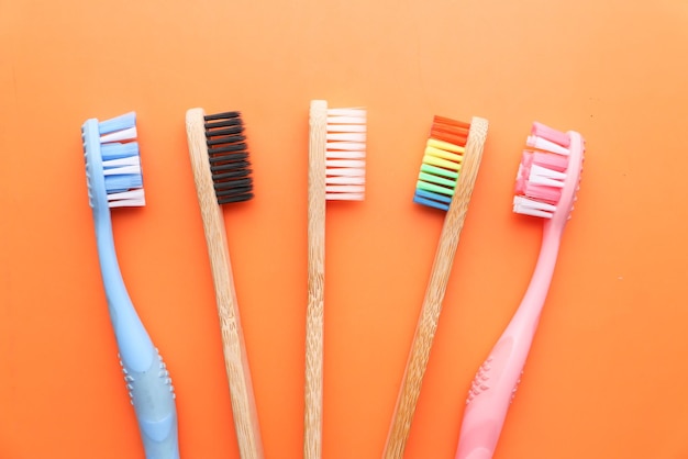 Primo piano di spazzolino da denti colorato su sfondo arancione