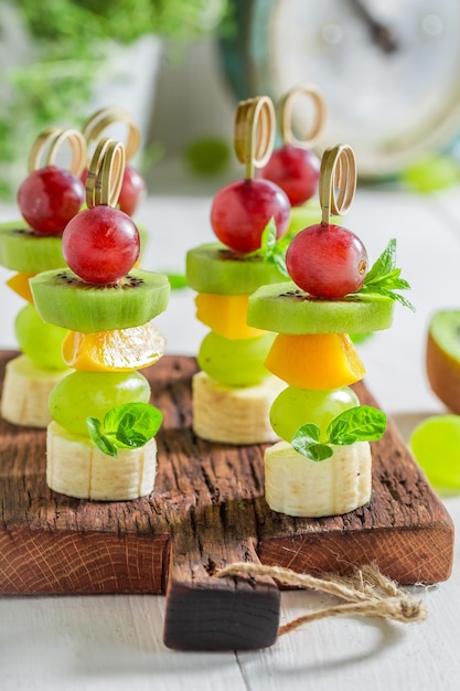 Primo piano di spiedini con vari frutti e menta per uno spuntino