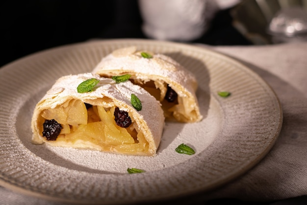 Primo piano di strudel austriaco di mele con cannella e menta su un piatto