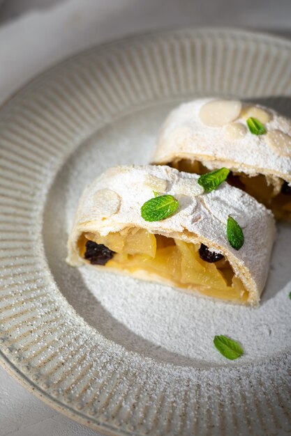 Primo piano di strudel austriaco di mele con cannella e menta su un piatto