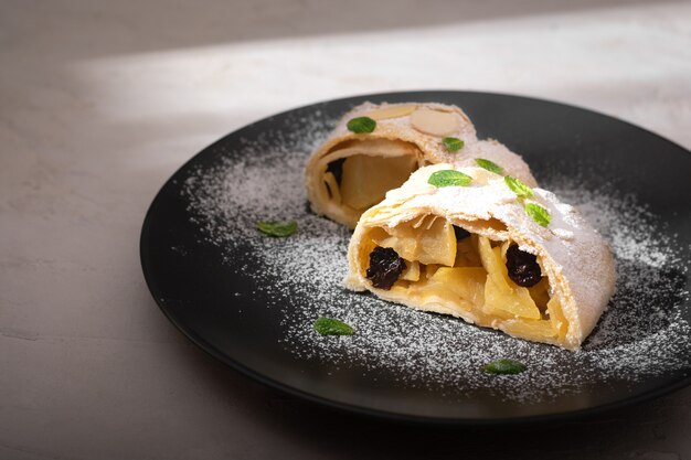 Primo piano di strudel austriaco di mele con cannella e menta su un piatto