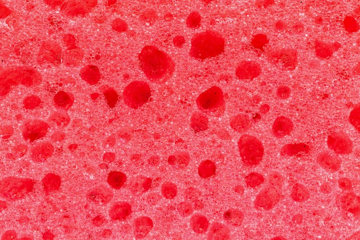 Foto primo piano di struttura rossa della schiuma della spugna, foto astratta del modello