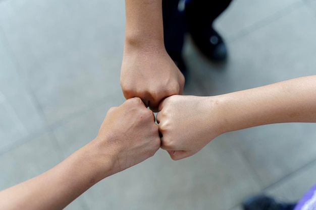 Primo piano di studenti in piedi con le mani che fanno il gesto del pugno