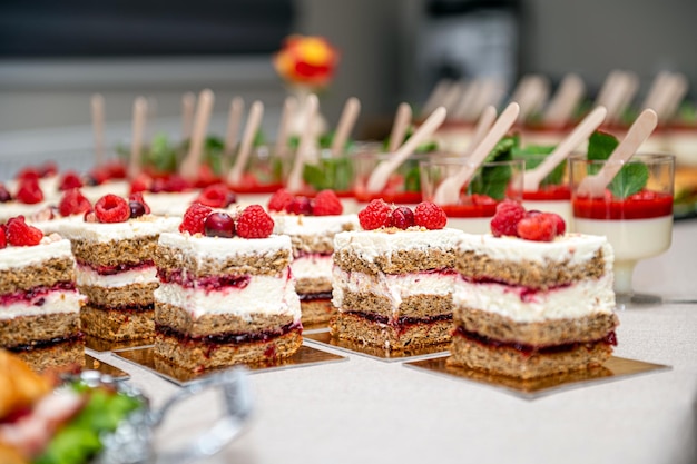 Primo piano di torte con frutta fresca e bacche disposte in fila su un tavolo da festa