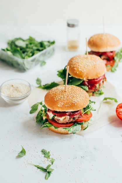 Primo piano di tre hamburger su un tavolo bianco