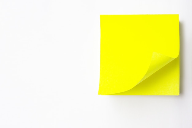 Primo piano di un adesivo bianco giallo Uno sfondo bianco. Nota gialla vuota con perno nero su sfondo giallo bianco. Nota adesiva gialla vuota