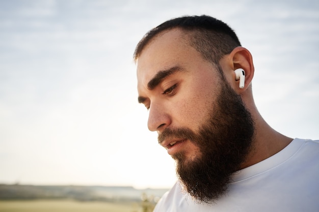 Primo piano di un atleta che ascolta musica mentre fa una passeggiata in campagna