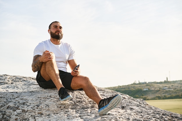 Primo piano di un atleta che ascolta musica mentre fa una passeggiata in campagna