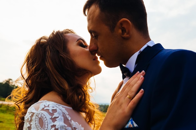 Primo piano di un bacio serale e dolci abbracci di sposi novelli