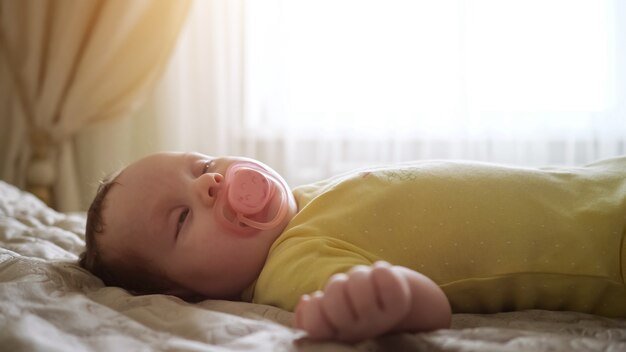 Primo piano di un bambino che dorme con un ciuccio in bocca