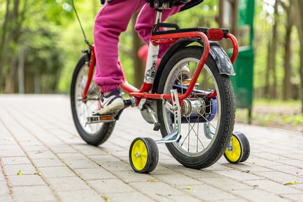 Primo piano di un bambino che va in bicicletta con tre ruote.