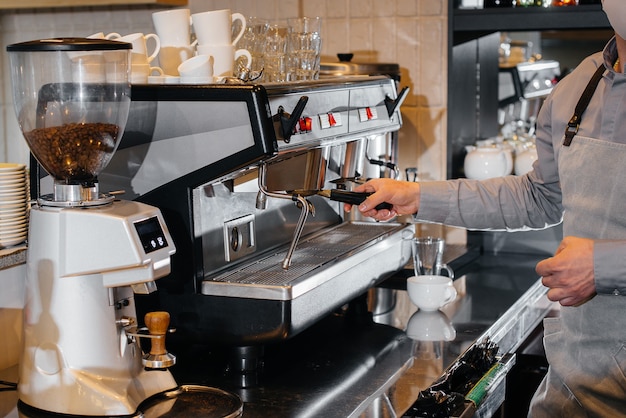 Primo piano di un barista mascherato che prepara un delizioso caffè al bar in un caffè