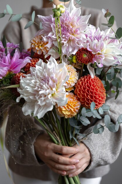 Primo piano di un bouquet festivo luminoso con crisantemi in mani femminili