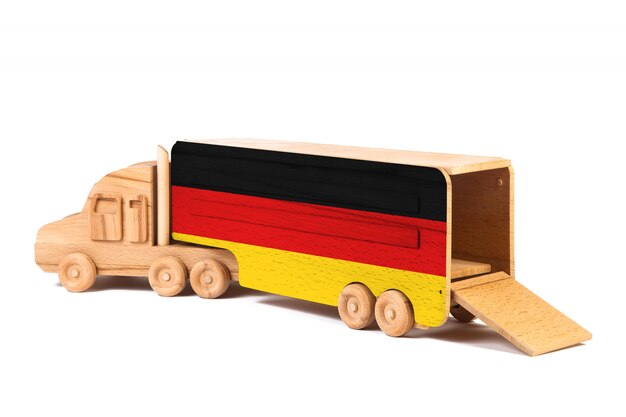 Primo piano di un camion di legno del giocattolo con una bandiera nazionale dipinta Germania. Il concetto di export-import, trasporto, consegna nazionale delle merci