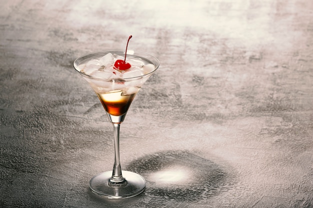 Primo piano di un cocktail alcolico con rum, ghiaccio e decorato con ciliegie rosse. Ricette concettuali e mixology.