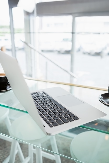 Primo piano di un computer portatile sul tavolo di vetro