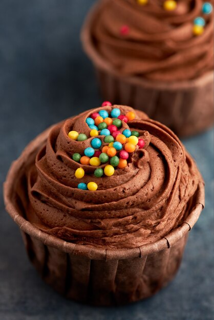 Primo piano di un cupcake al cioccolato con caramelle colorate.