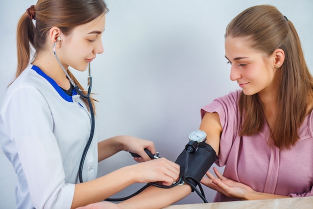 Primo piano di un dottore Checking Blood Pressure di un paziente. Concetto di servizio medico.