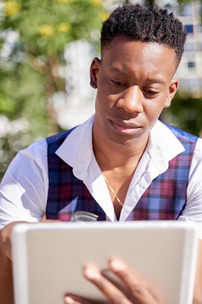 Primo piano di un giovane afroamericano che utilizza il suo tablet pc