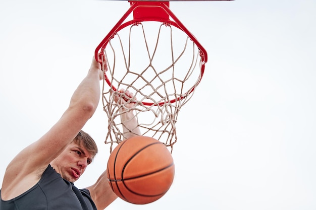 Primo piano di un giovane giocatore di basket che fa schiacciata