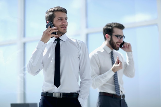 Primo piano di un giovane uomo d'affari di successo che parla sul concetto di smartphonebusiness