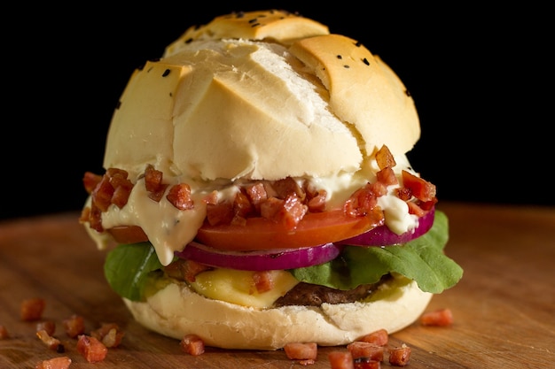 Primo piano di un hamburger fatto in casa con pancetta e insalata