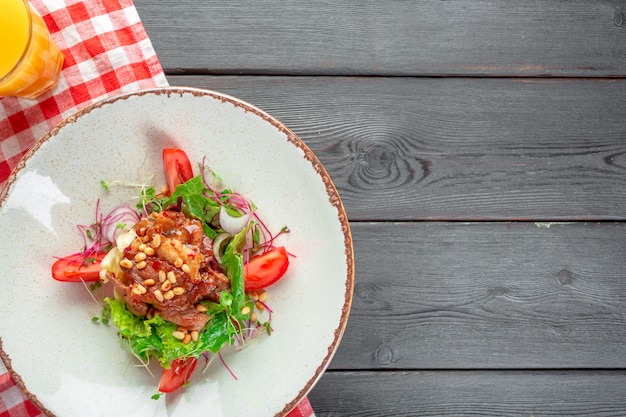 Primo piano di un'insalata verde fresca con la bistecca di filetto scottata affettata