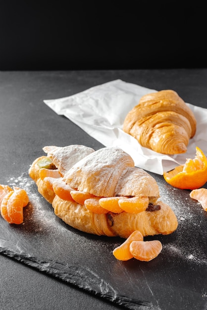 Primo piano di un mucchio di deliziosi croissant su uno sfondo scuro croissant fatti in casa