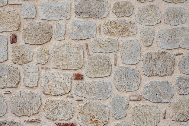 Primo piano di un muro antico marrone strada con dettagli in rilievo. Motivo a piastrelle