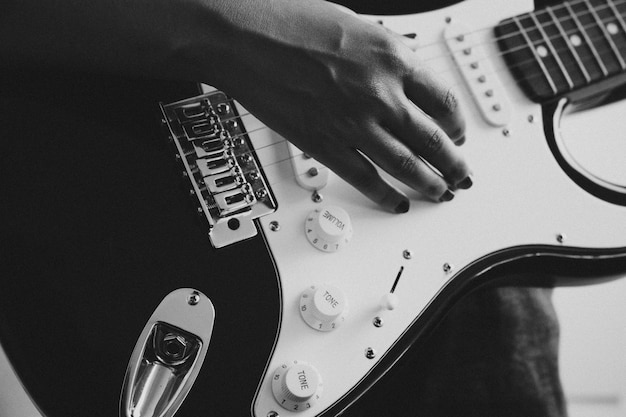 Primo piano di un paio di mani che suonano una chitarra all'aperto. Giornata di sole e pratica di un concetto di strumento. Copia spazio musica vita in tour e natura.